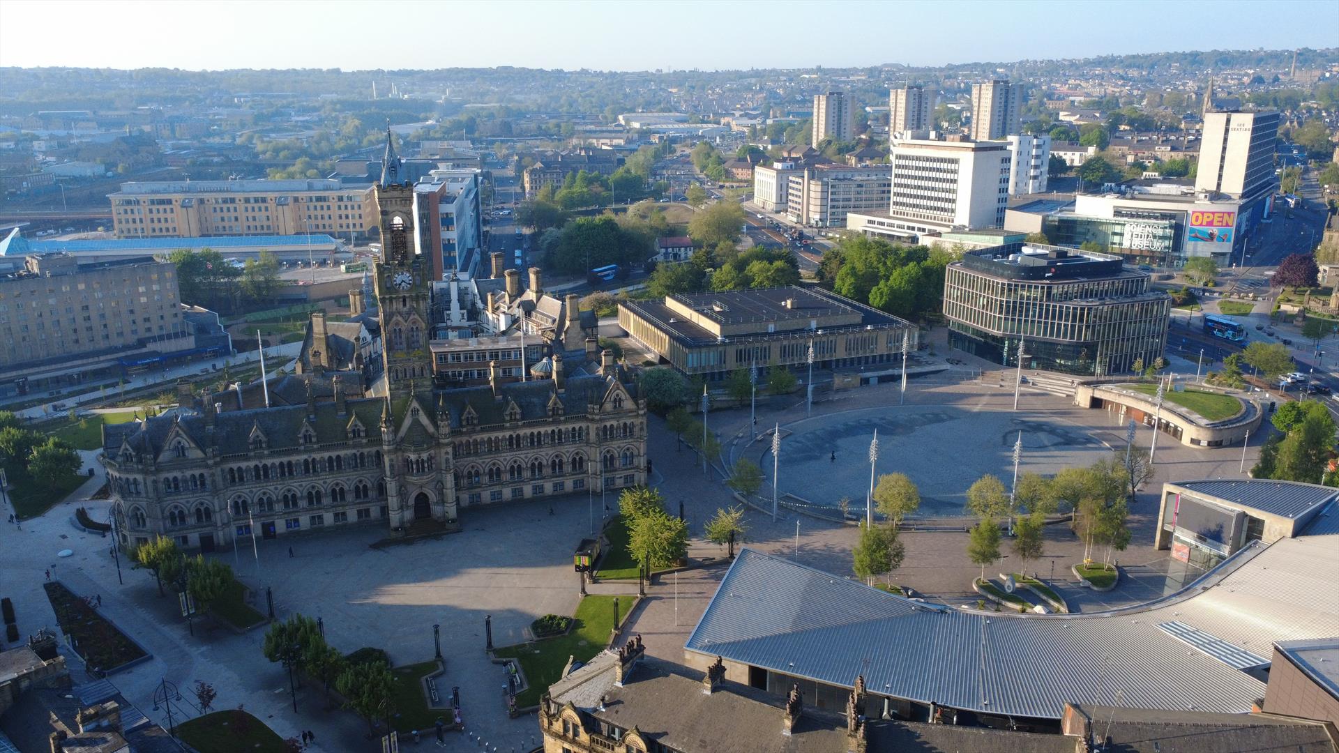 Aerial view of Bradford city centre with the gothic City Hall clock tower, Centenary Square and surrounding skyline