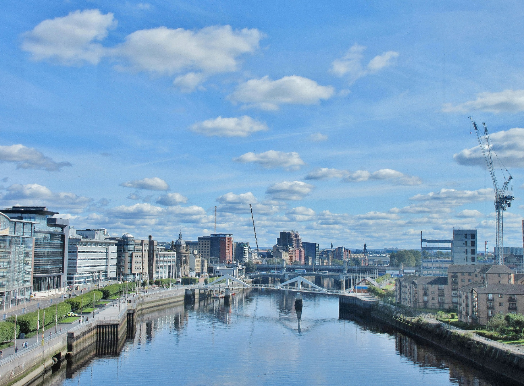 Glasgow city skyline along the River Clyde with the Tradeston Squiggly Bridge and waterfront buildings